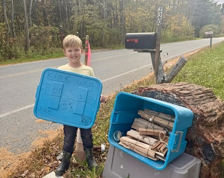 image of a boy holding kindling.